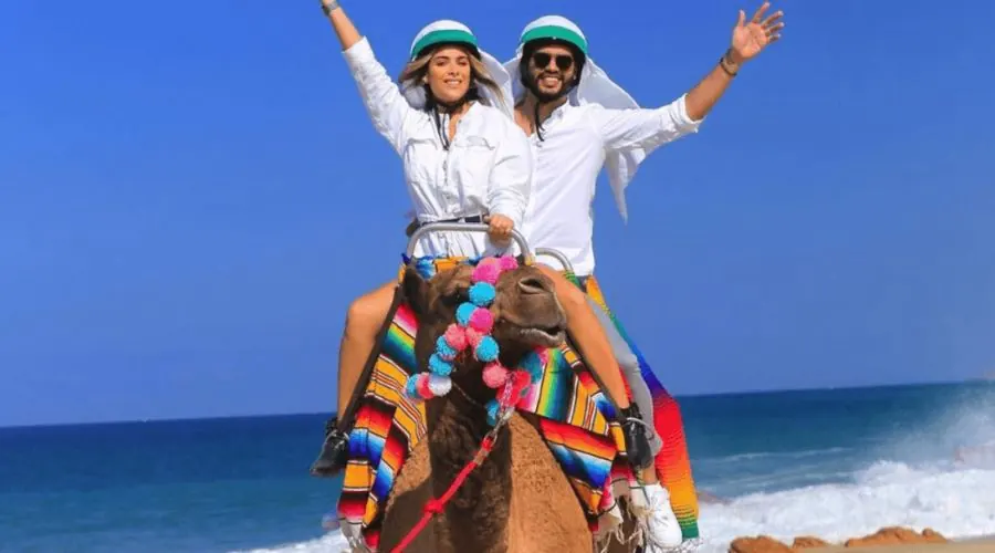 Guests on a camel ride by the sea