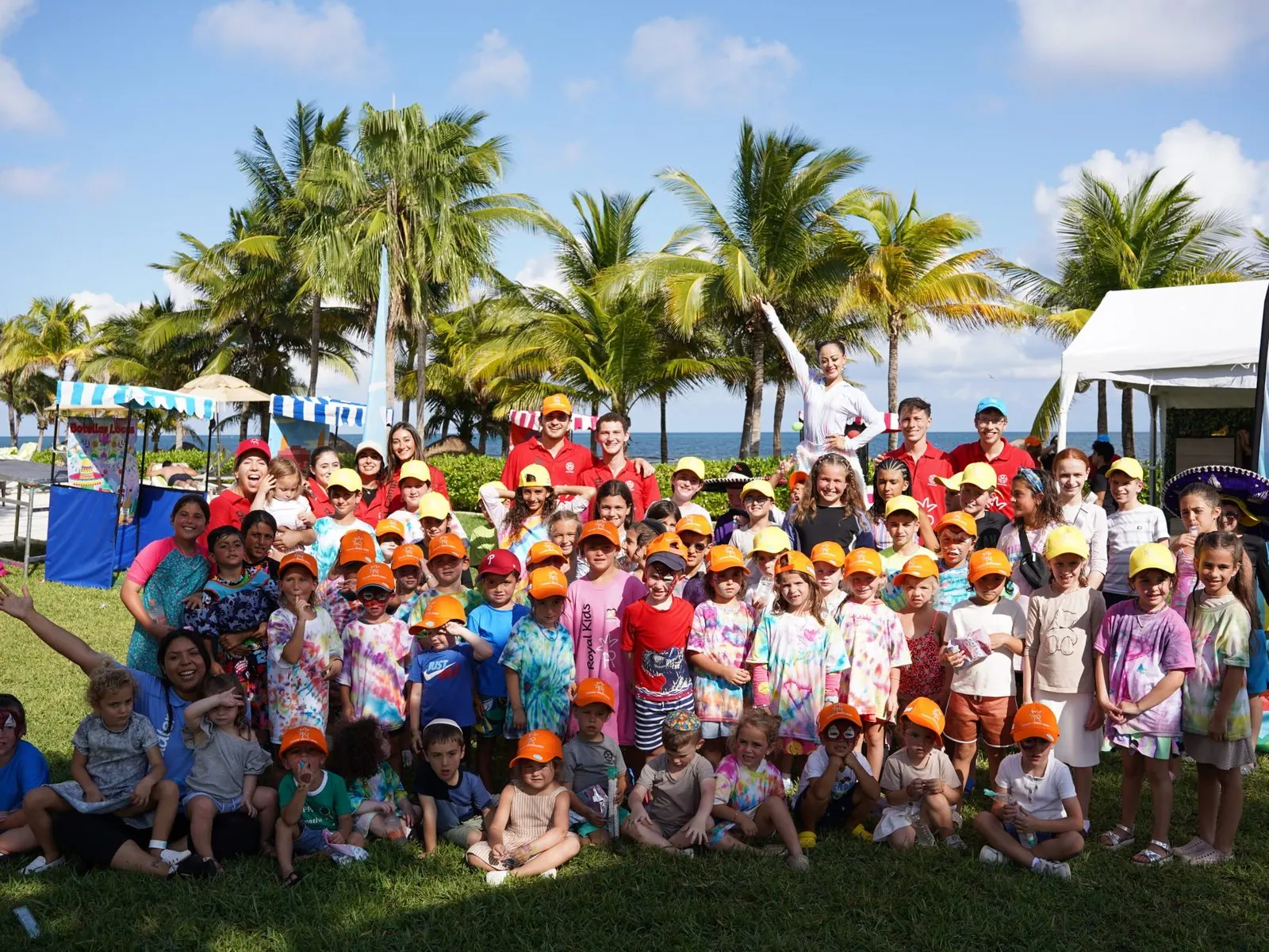 KIDIS campers in their caps on the lawn by the beach